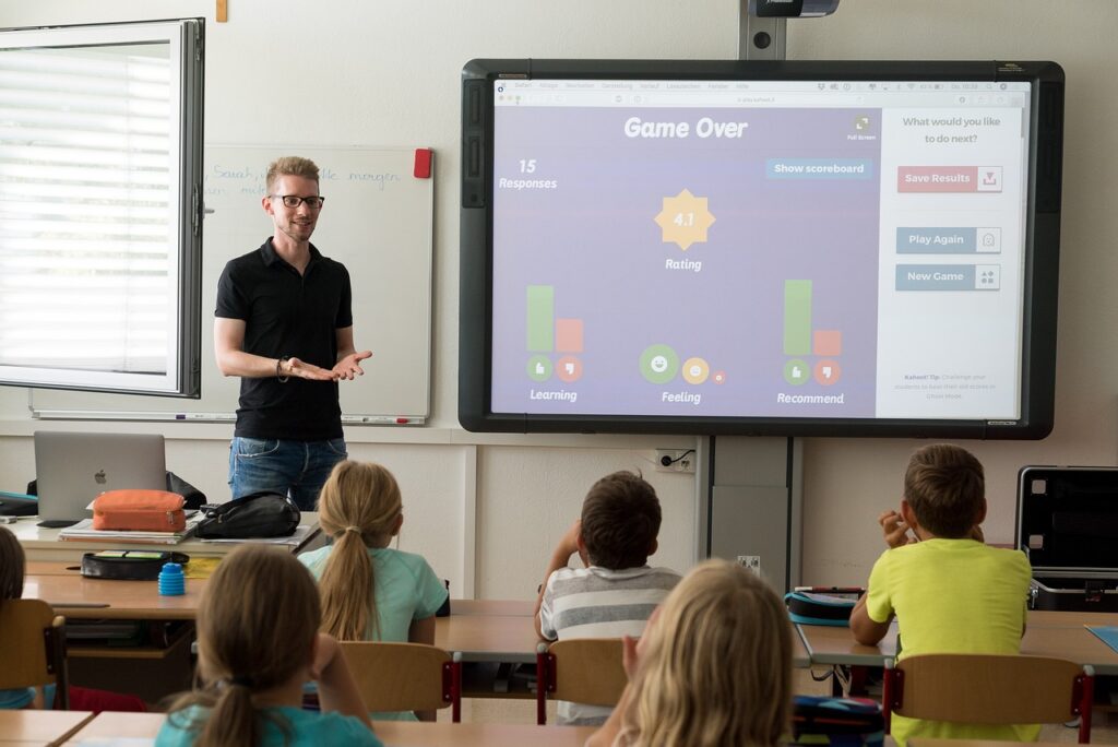 Teacher presenting a game project on a screen to students